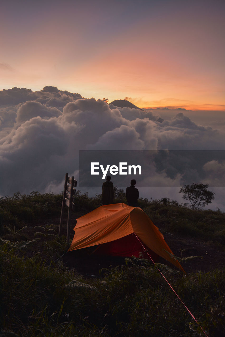 Tent on field against sky during sunset