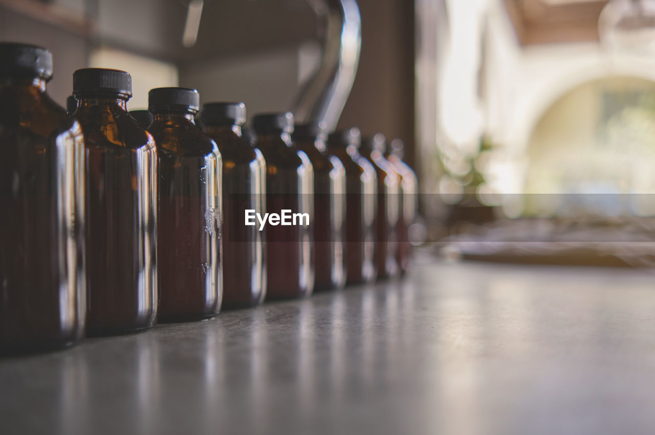 CLOSE-UP OF BOTTLES IN GLASS ON TABLE