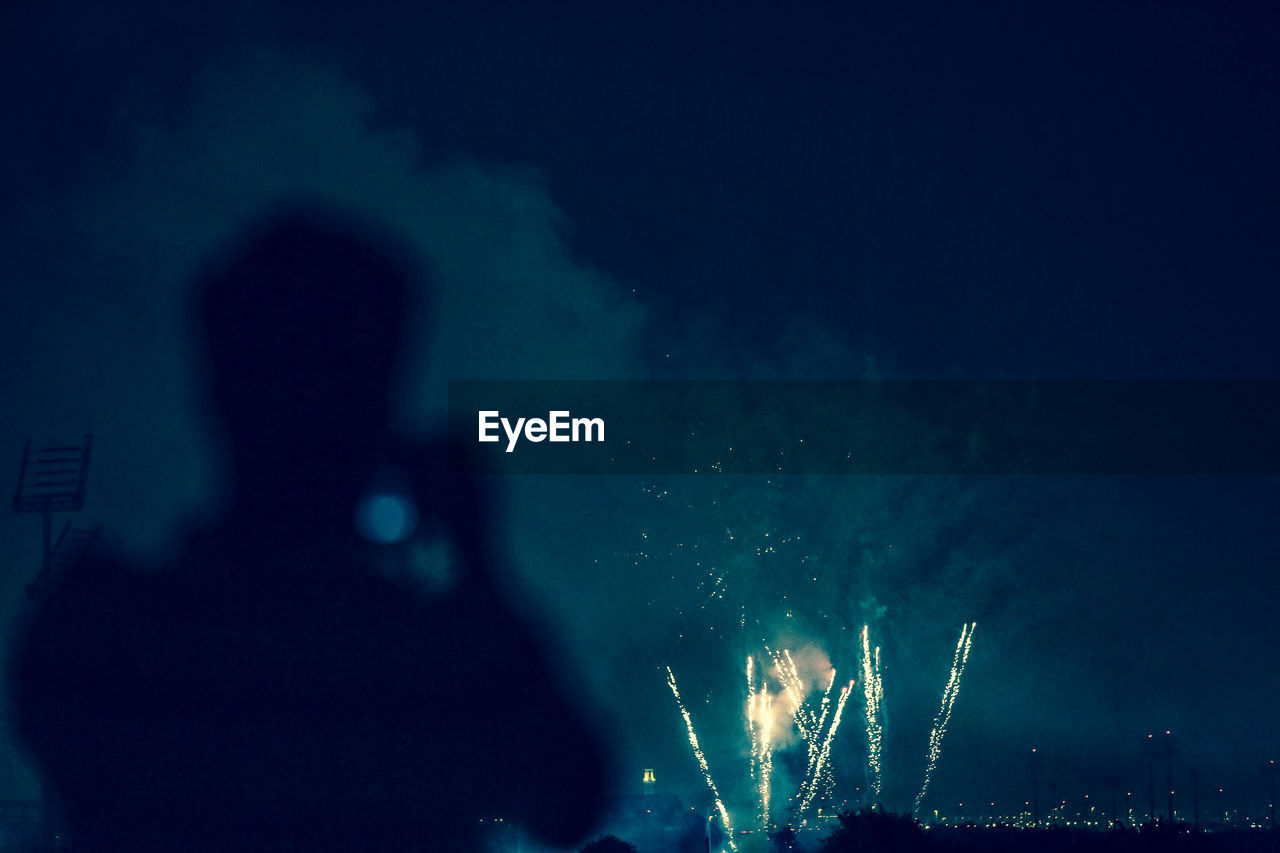 Silhouette man against firework