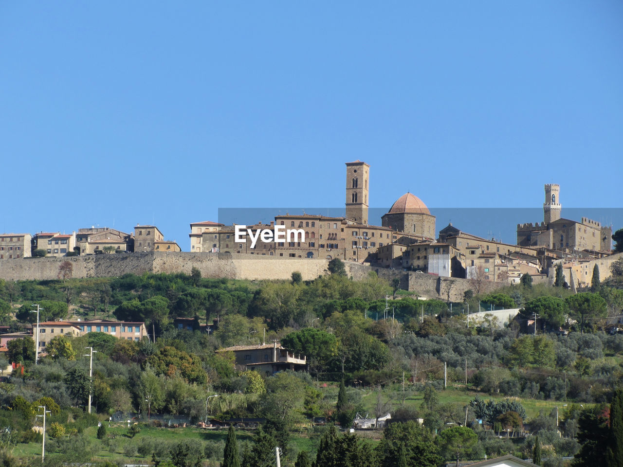 Buildings in city against blue sky