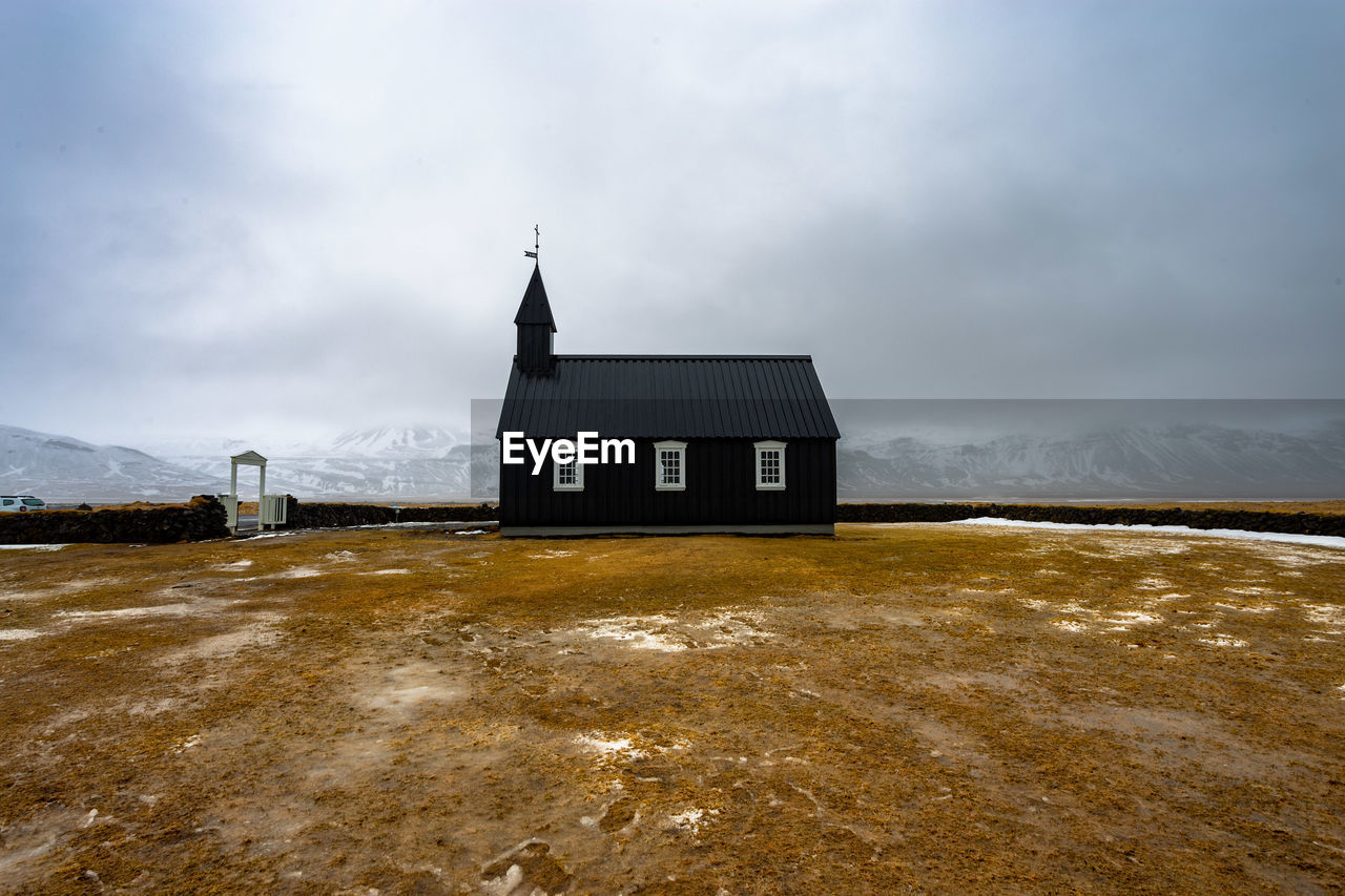 Black church of budhir with mountains coverd in snow in the background