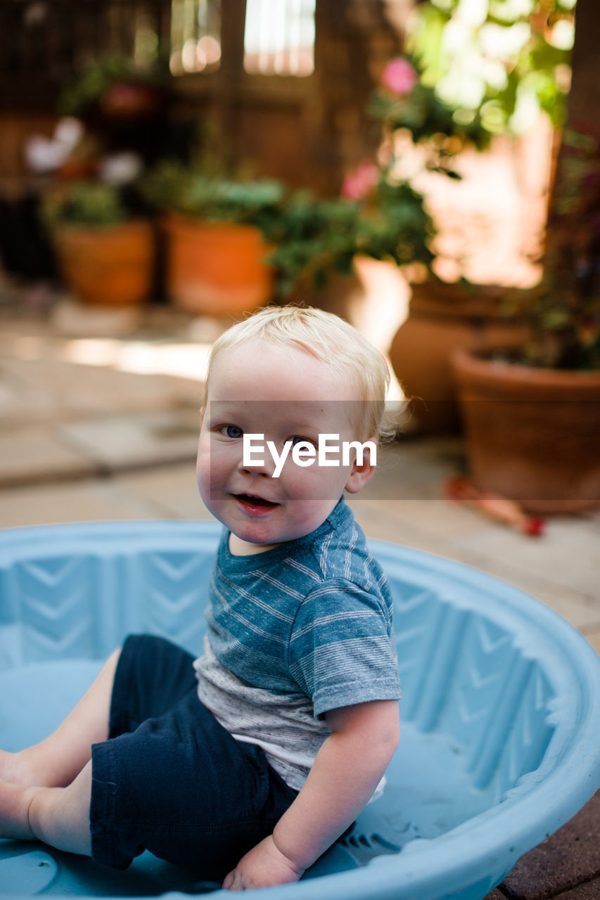 One year old boy sitting in pool in yard in san diego