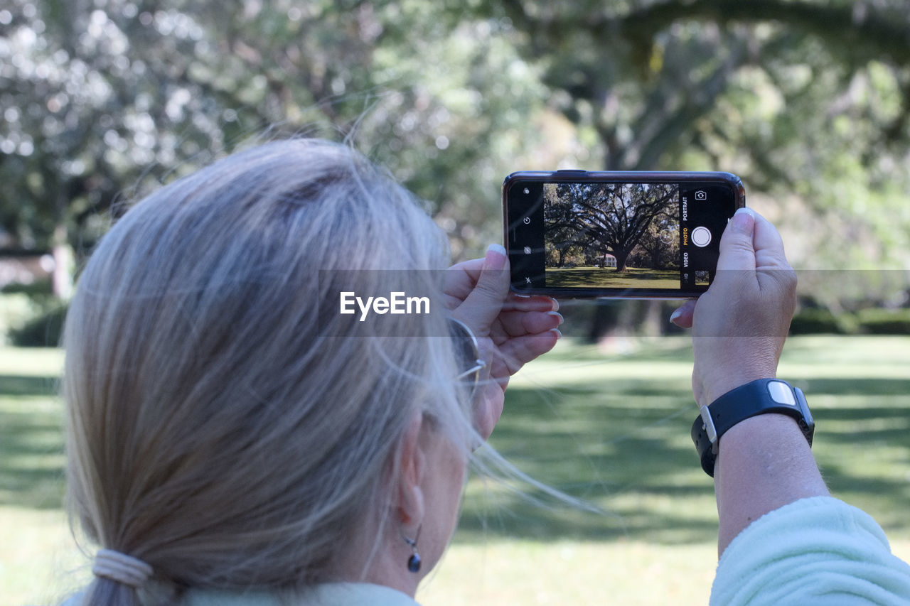 PORTRAIT OF WOMAN PHOTOGRAPHING WITH SMART PHONE