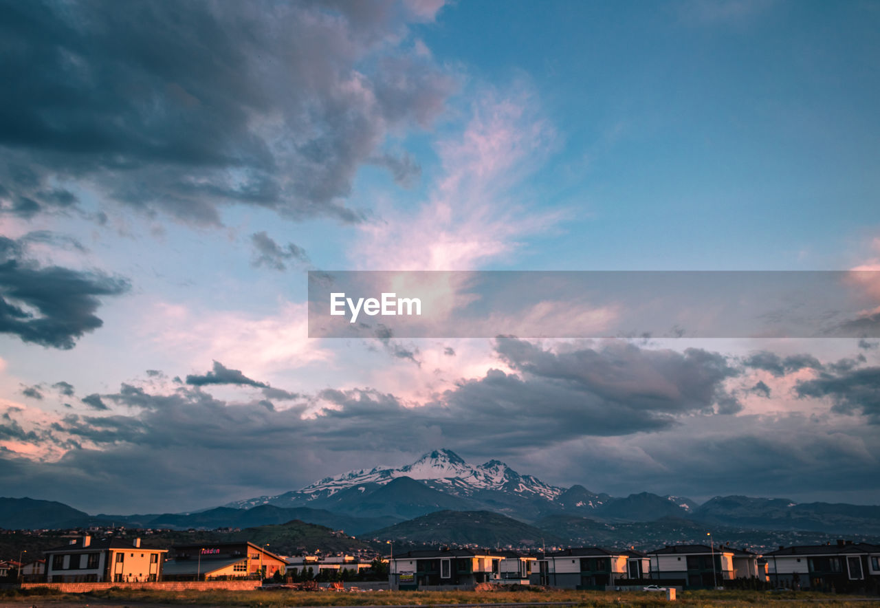 Scenic view of townscape against sky at sunset