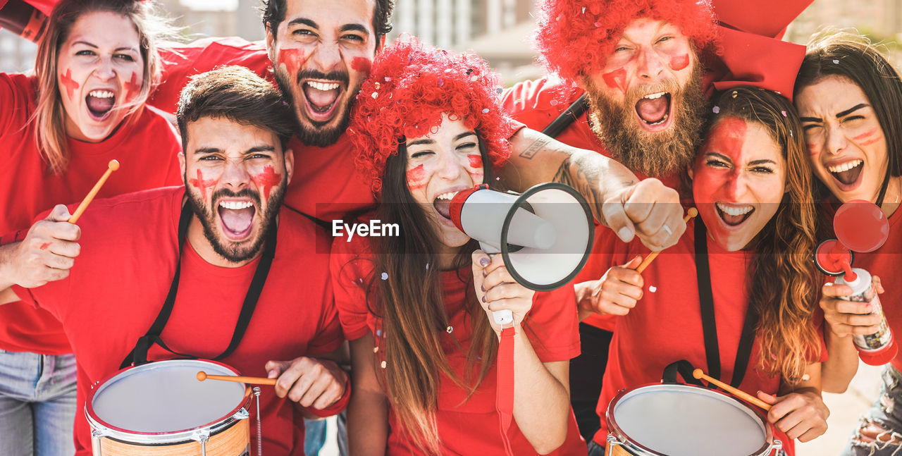 Portrait of cheerful fans screaming outdoors