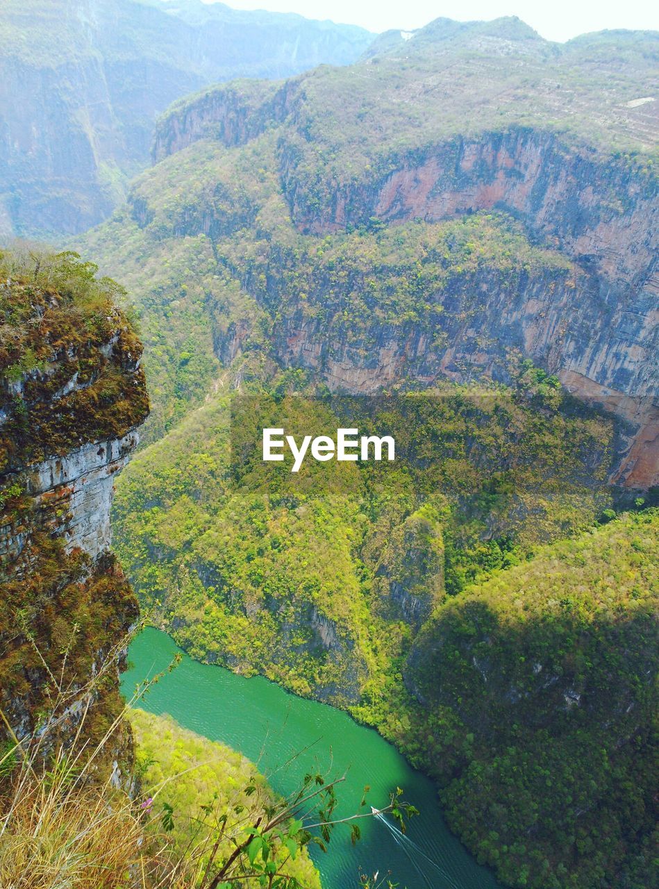 HIGH ANGLE VIEW OF RIVER AMIDST MOUNTAINS