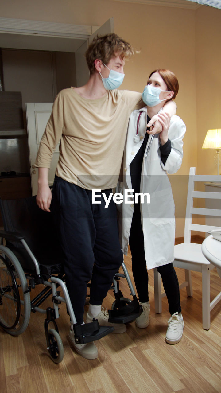 Young man with woman standing on floor at home