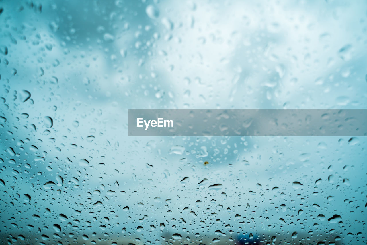 FULL FRAME SHOT OF WET GLASS WINDOW DURING RAINY SEASON