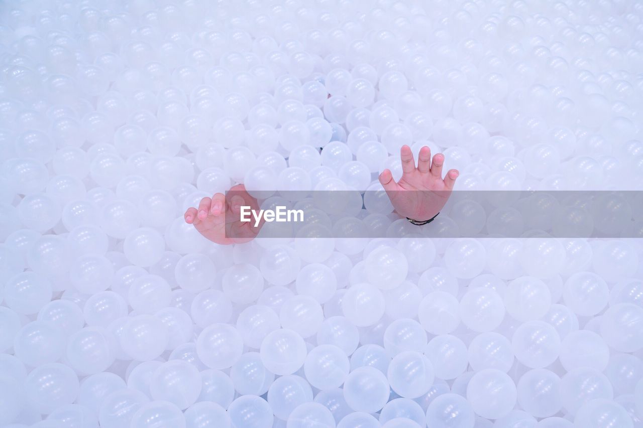 High angle view of hands coming out from balls