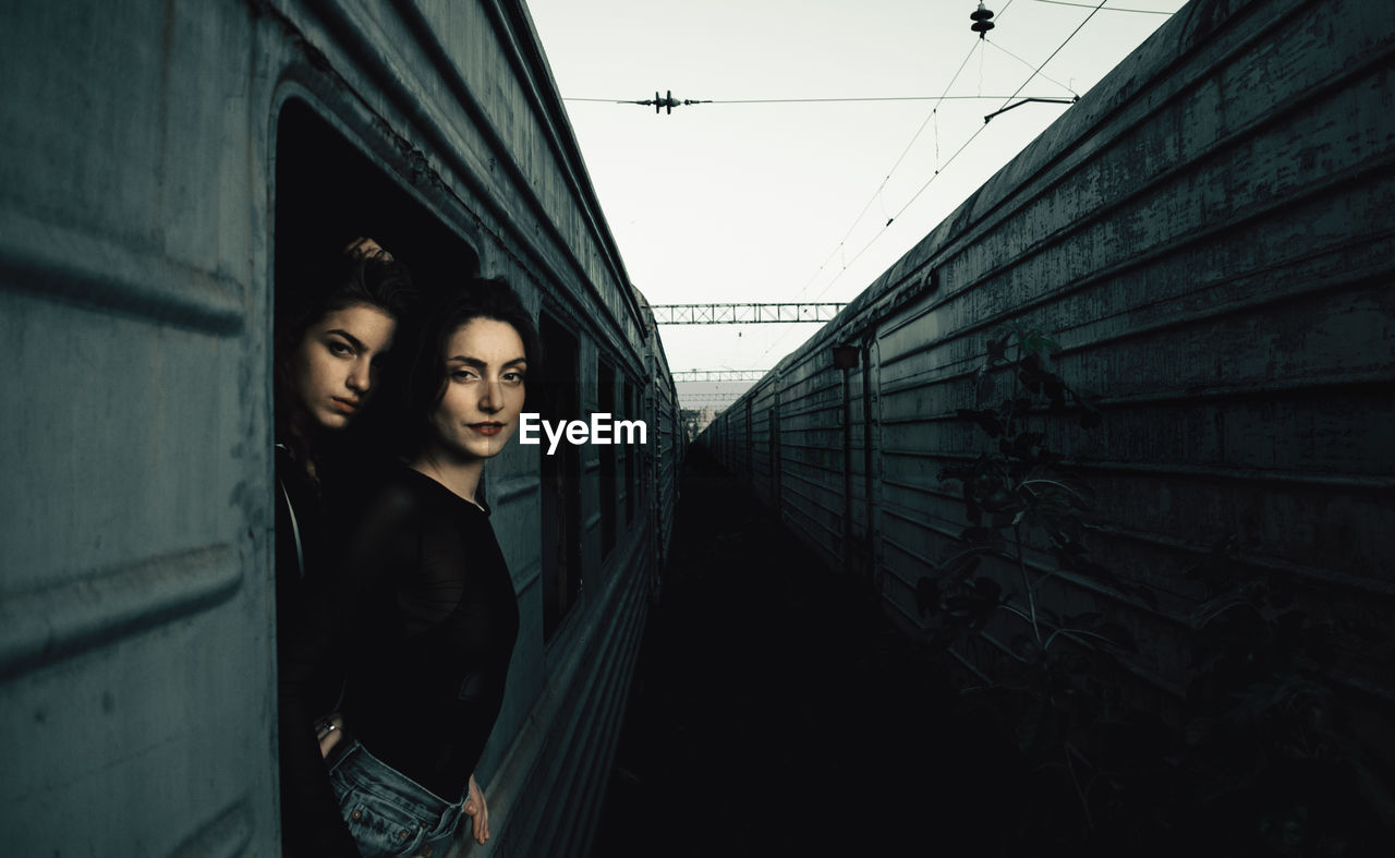 Portrait of young women peeking out from train window
