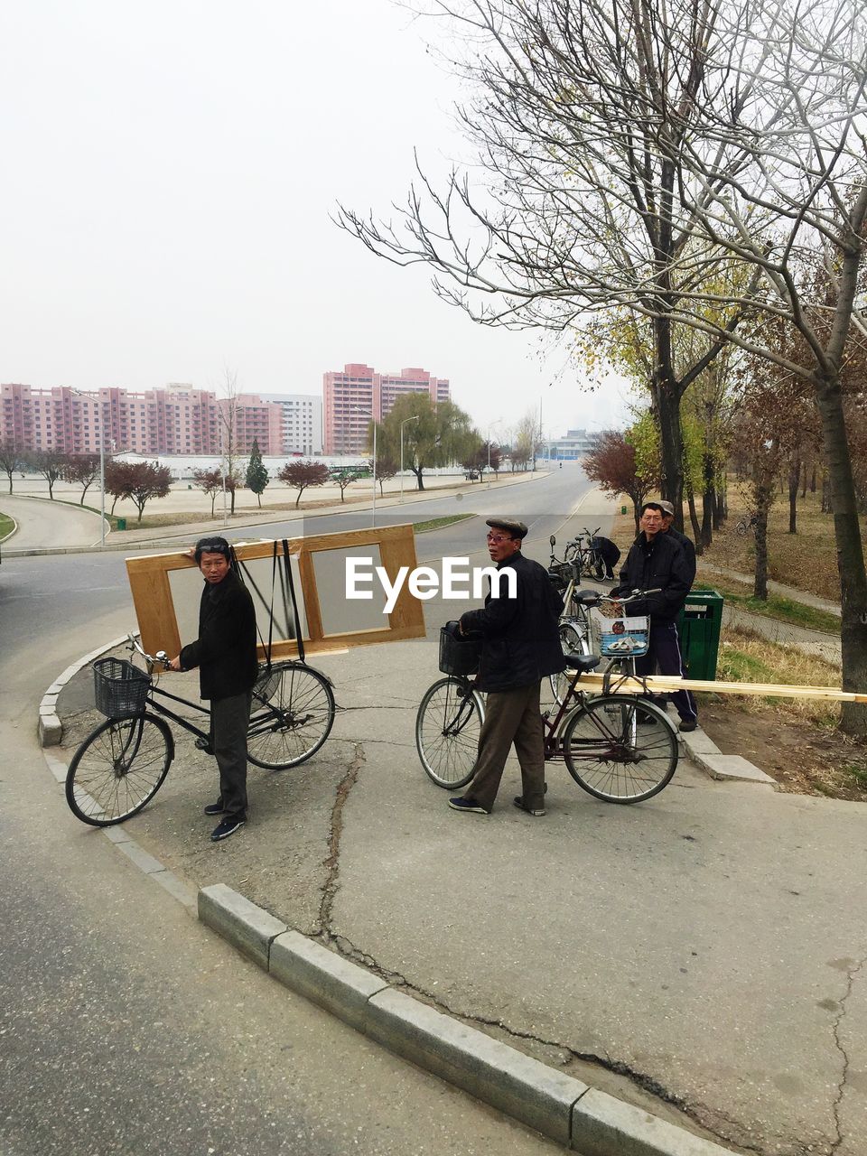 REAR VIEW OF PEOPLE RIDING BICYCLE ON ROAD