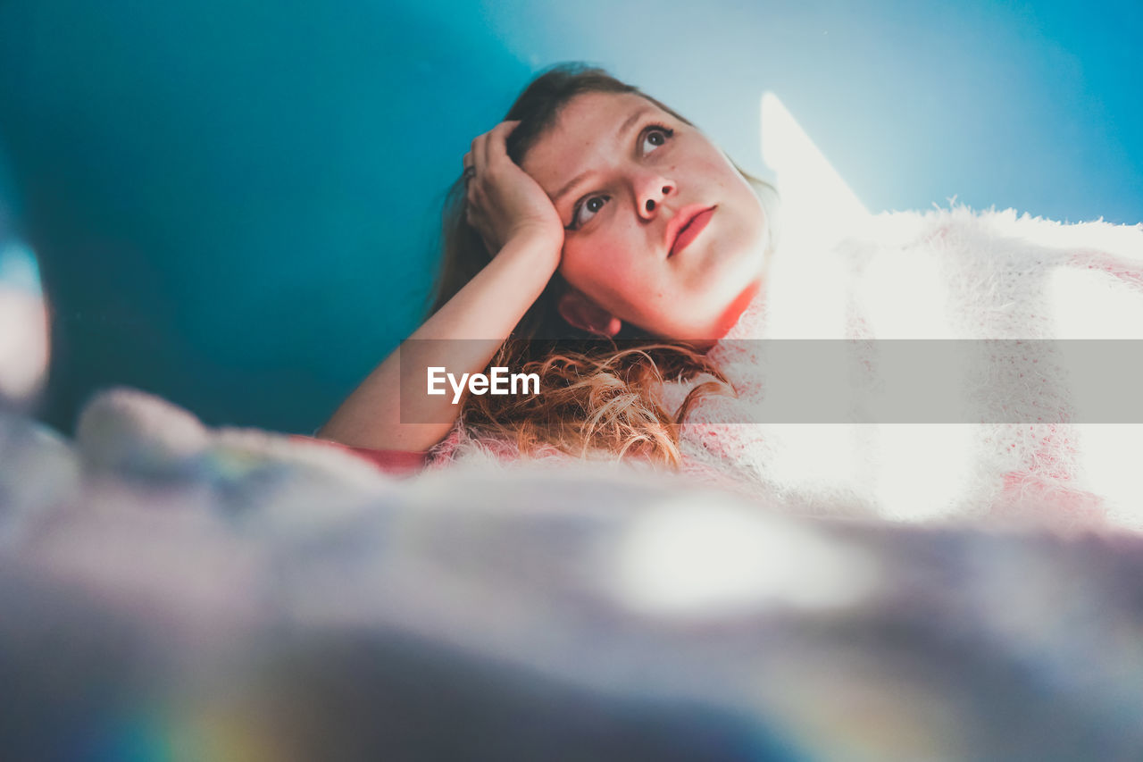 PORTRAIT OF A YOUNG WOMAN LYING DOWN ON FLOOR