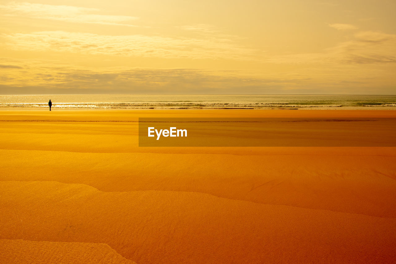 Scenic view of beach against sky during sunset