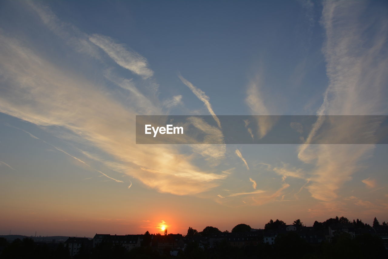 Silhouette townscape against sky during sunset