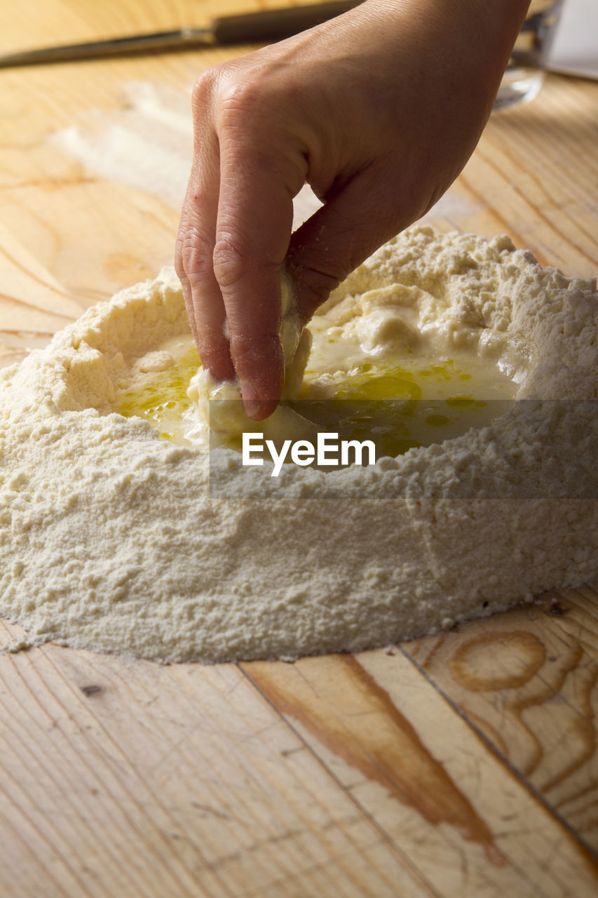 Cropped image of hand preparing ravioli dough on table