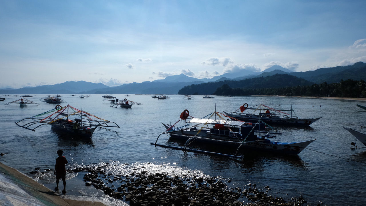 PEOPLE ON BOAT IN SEA AGAINST SKY