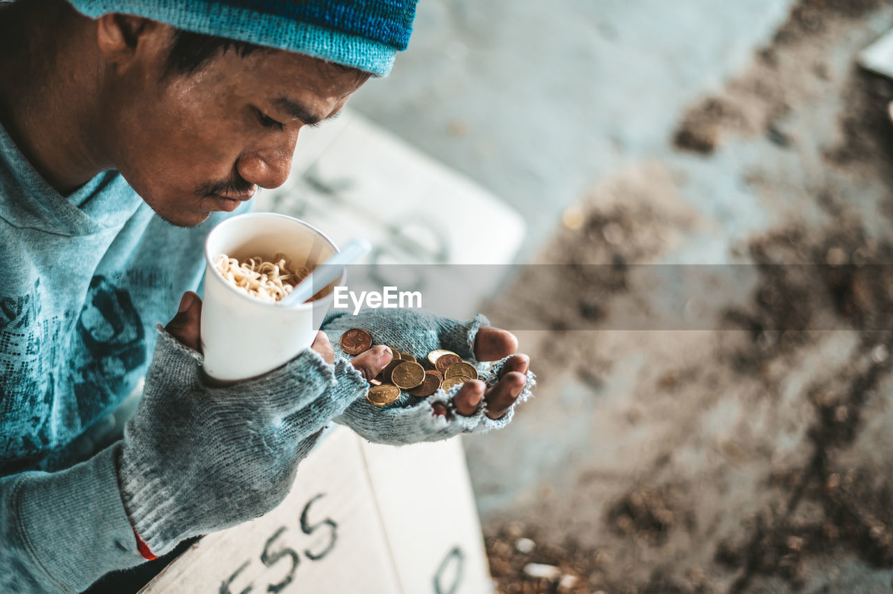 MIDSECTION OF MAN HOLDING COFFEE