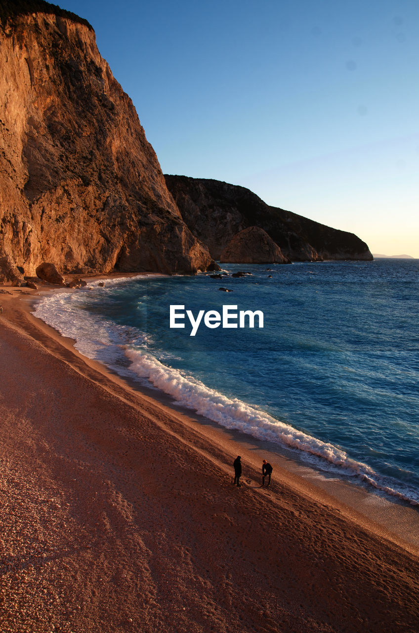 Scenic view of beach against sky at sunset