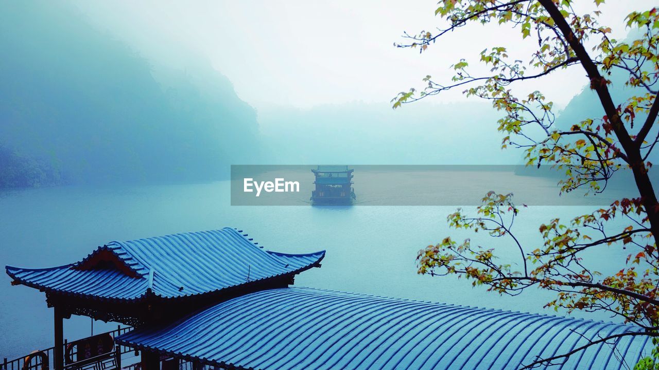 Scenic view of boat in calm sea through fog