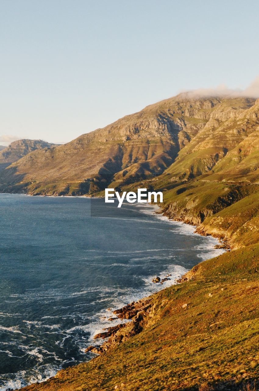 Scenic view of sea and mountains against clear sky