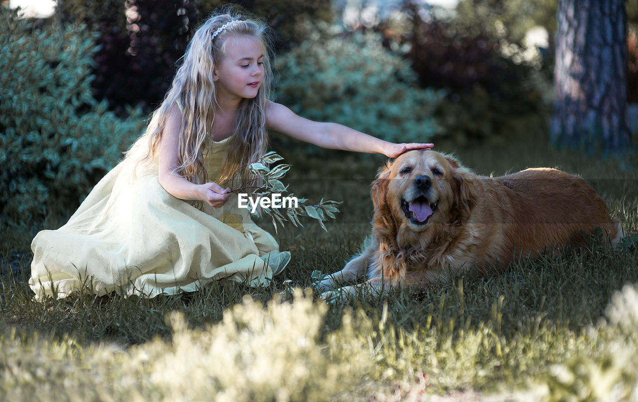 Girl with dog sitting on grass