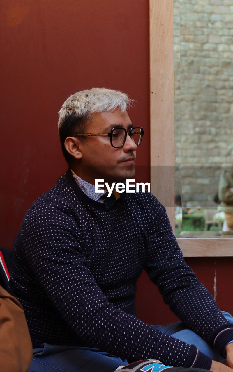 Man looking away while sitting on chair