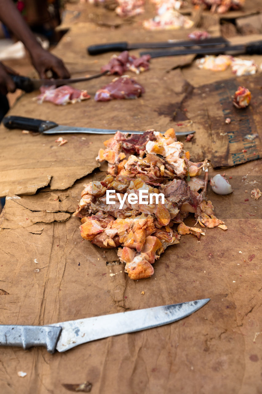 Cropped image of person chopping meat in butcher shop