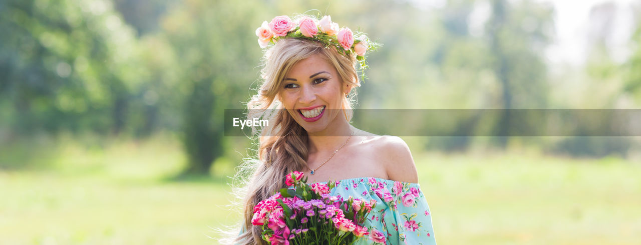 Portrait of smiling young woman against blue sky