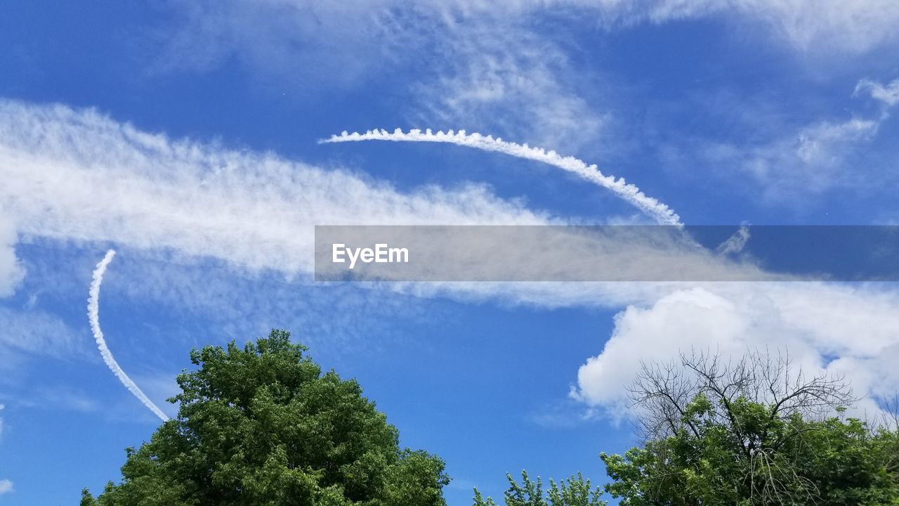 LOW ANGLE VIEW OF VAPOR TRAILS AGAINST SKY