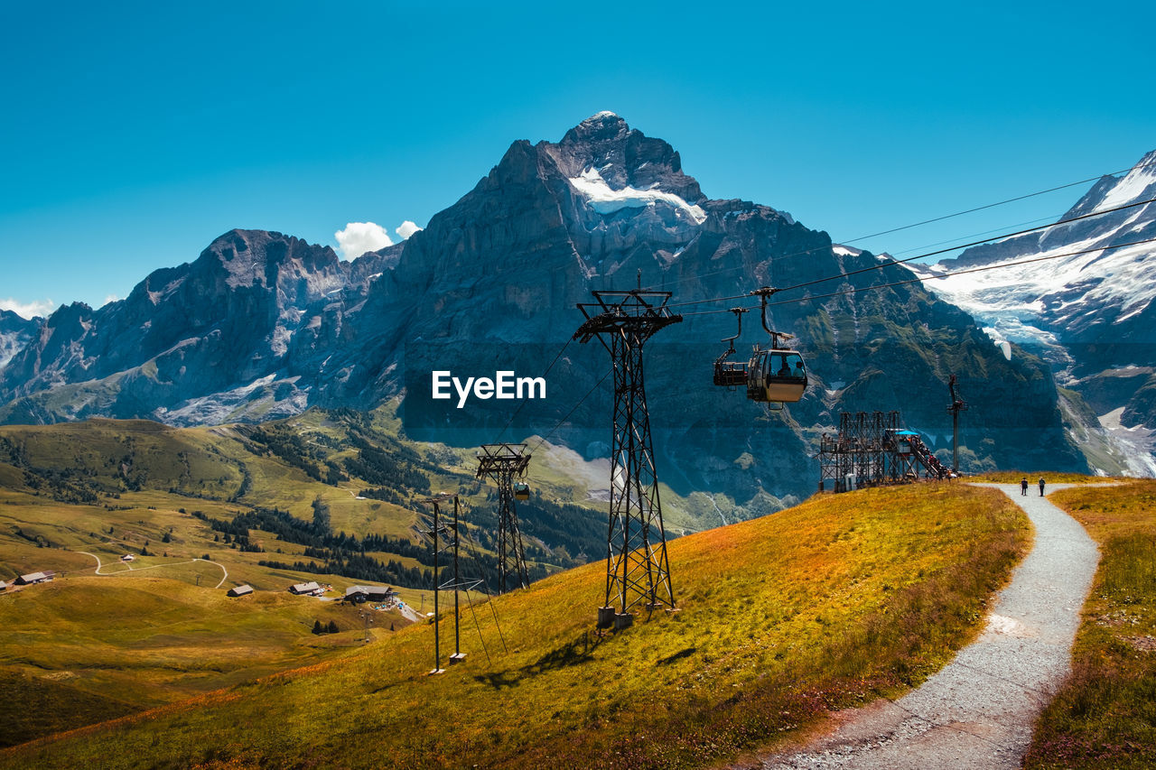 Scenic view of snowcapped mountains against blue sky