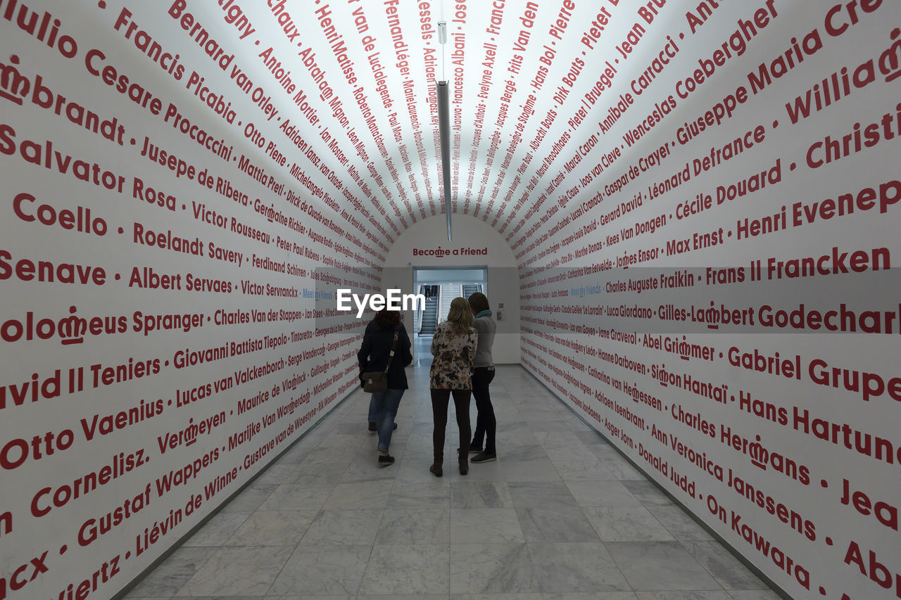 FULL LENGTH REAR VIEW OF PEOPLE WALKING IN CORRIDOR