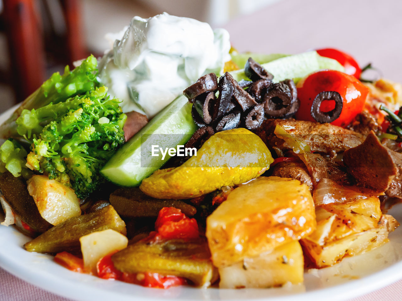 Healthy dinner - plate full of stewed vegetables, rice and meat with natural yogurt.