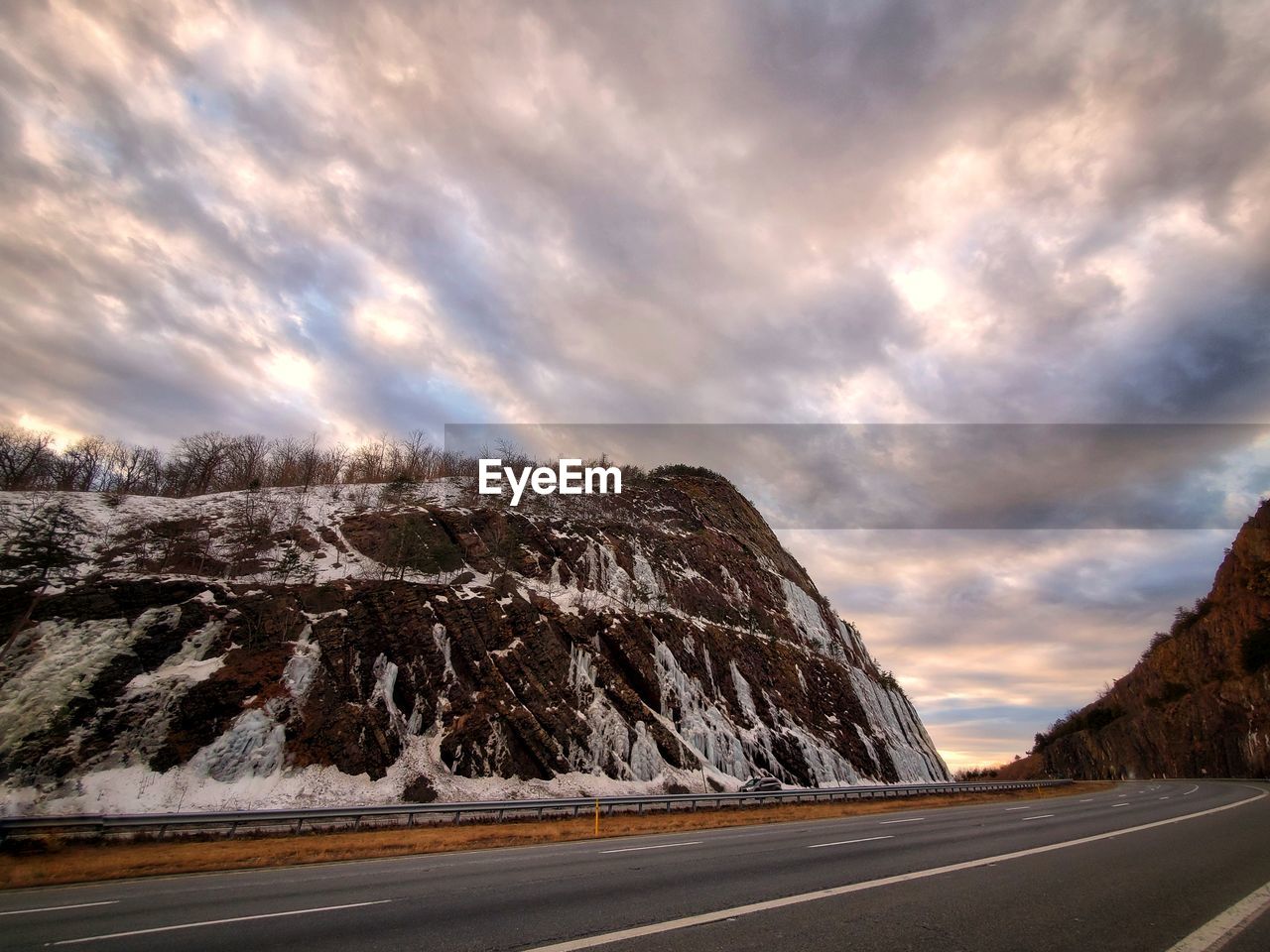 Road by mountain against sky during sunset