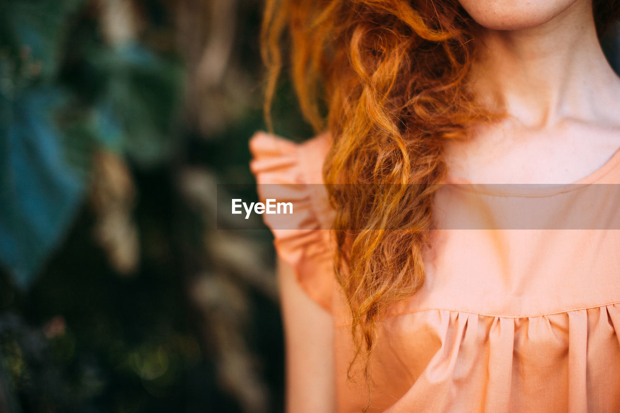 Midsection of young woman standing outdoors