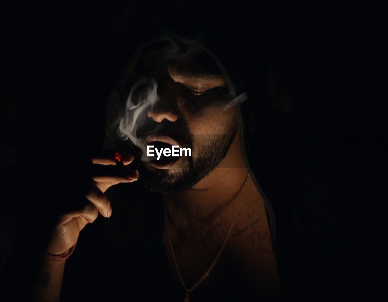 Man smoking cigarette in dark