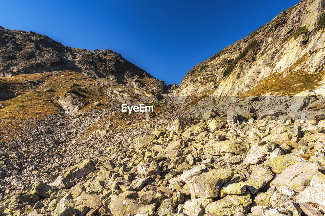 Low angle view of rocky mountains against clear sky