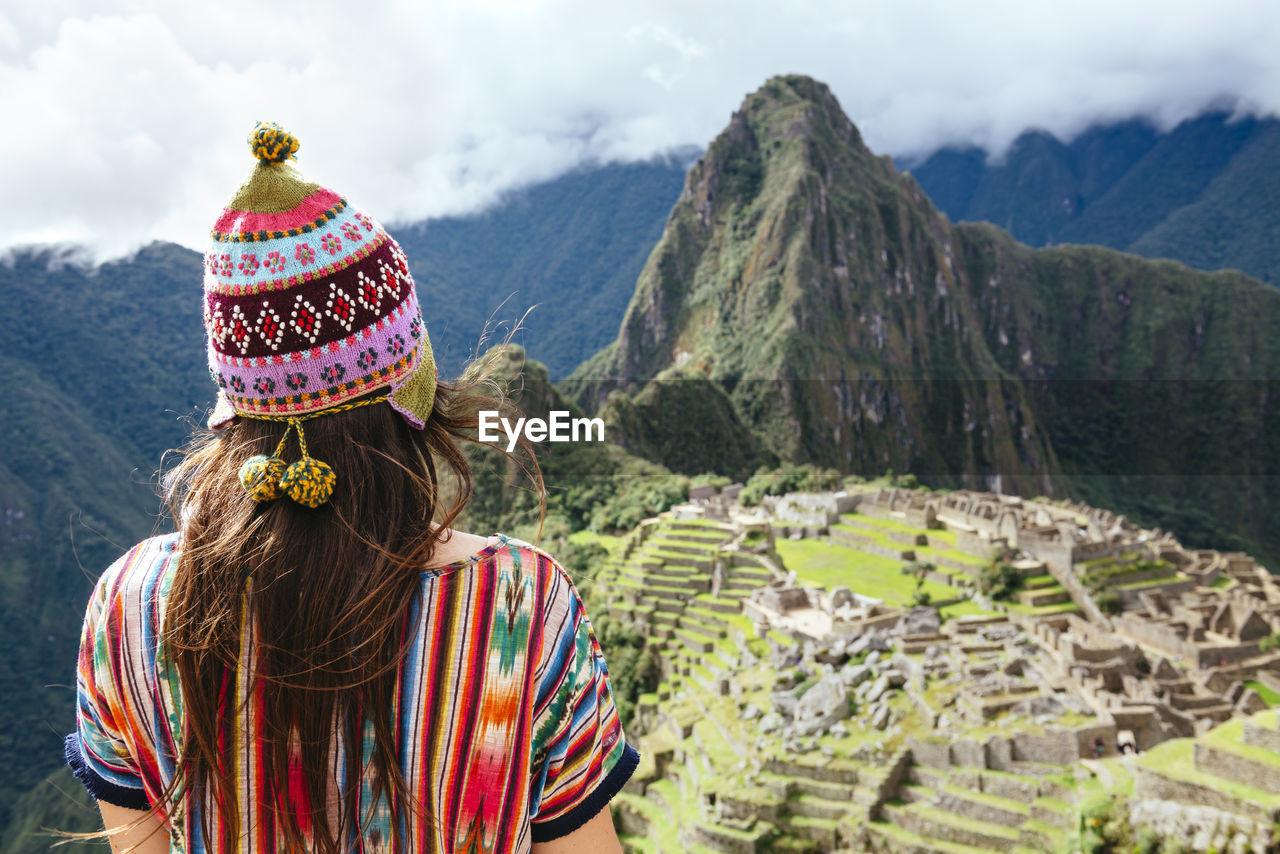 Peru, machu picchu region, female traveler looking at machu picchu citadel and huayna mountain