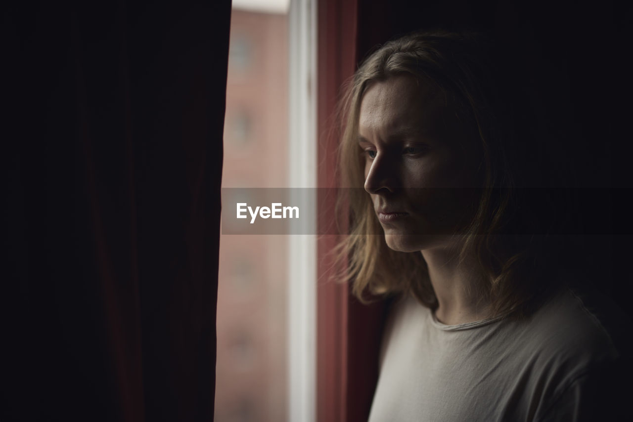 Thoughtful man looking through window