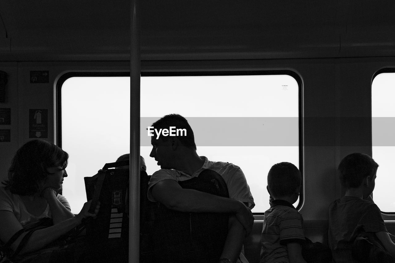 People standing by window of train