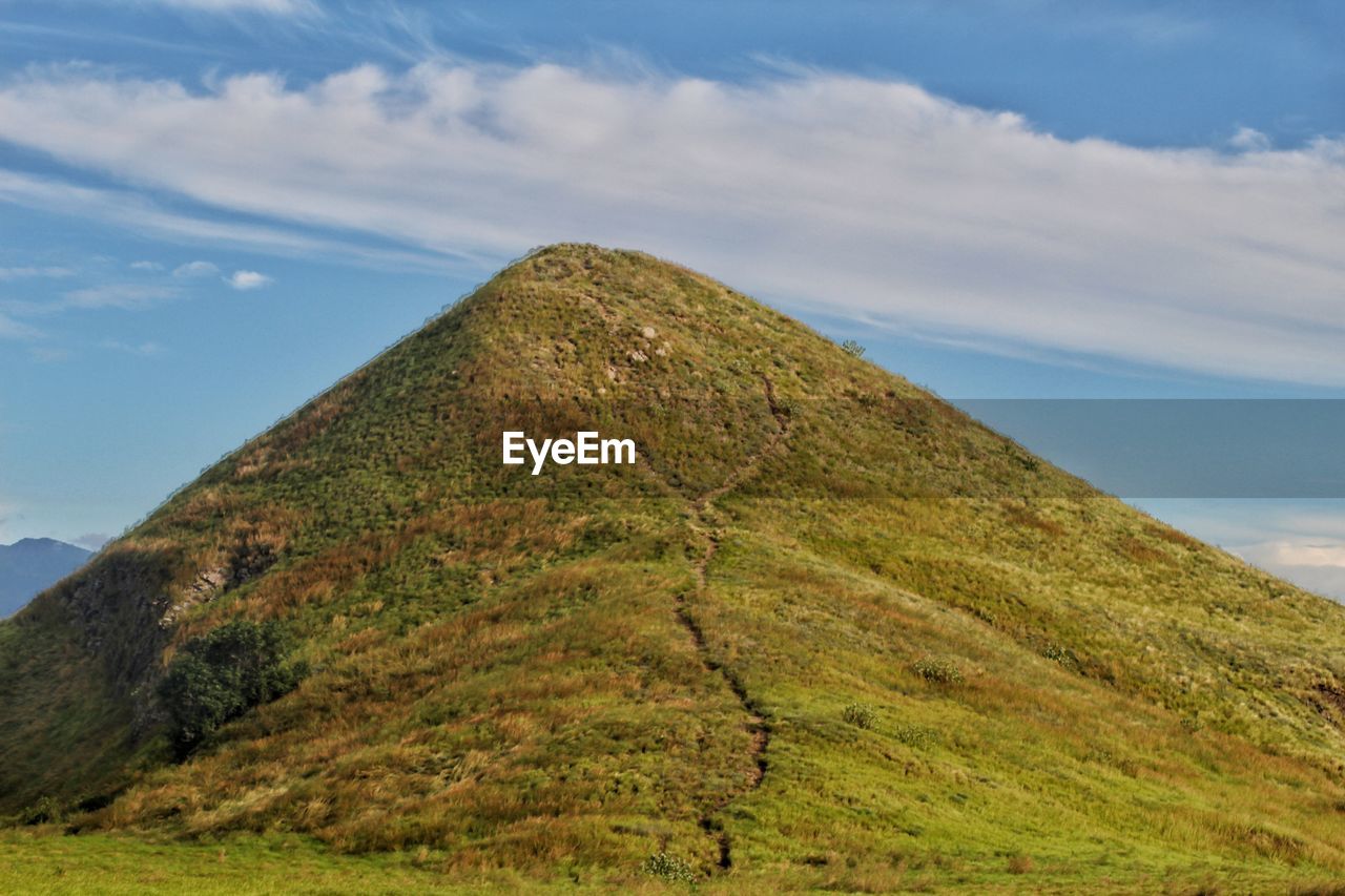 Scenic view of hill against sky