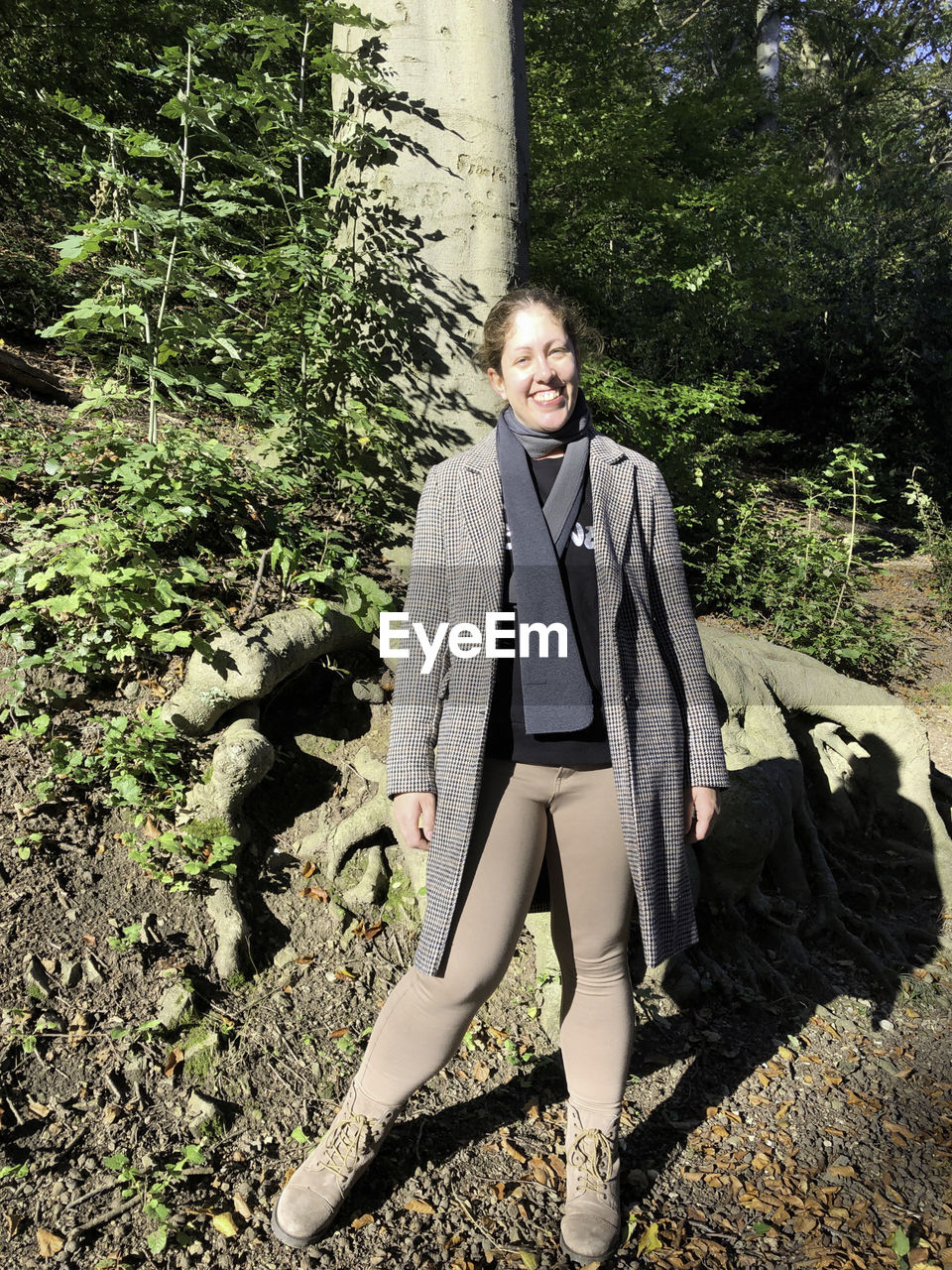 PORTRAIT OF YOUNG WOMAN STANDING IN FOREST