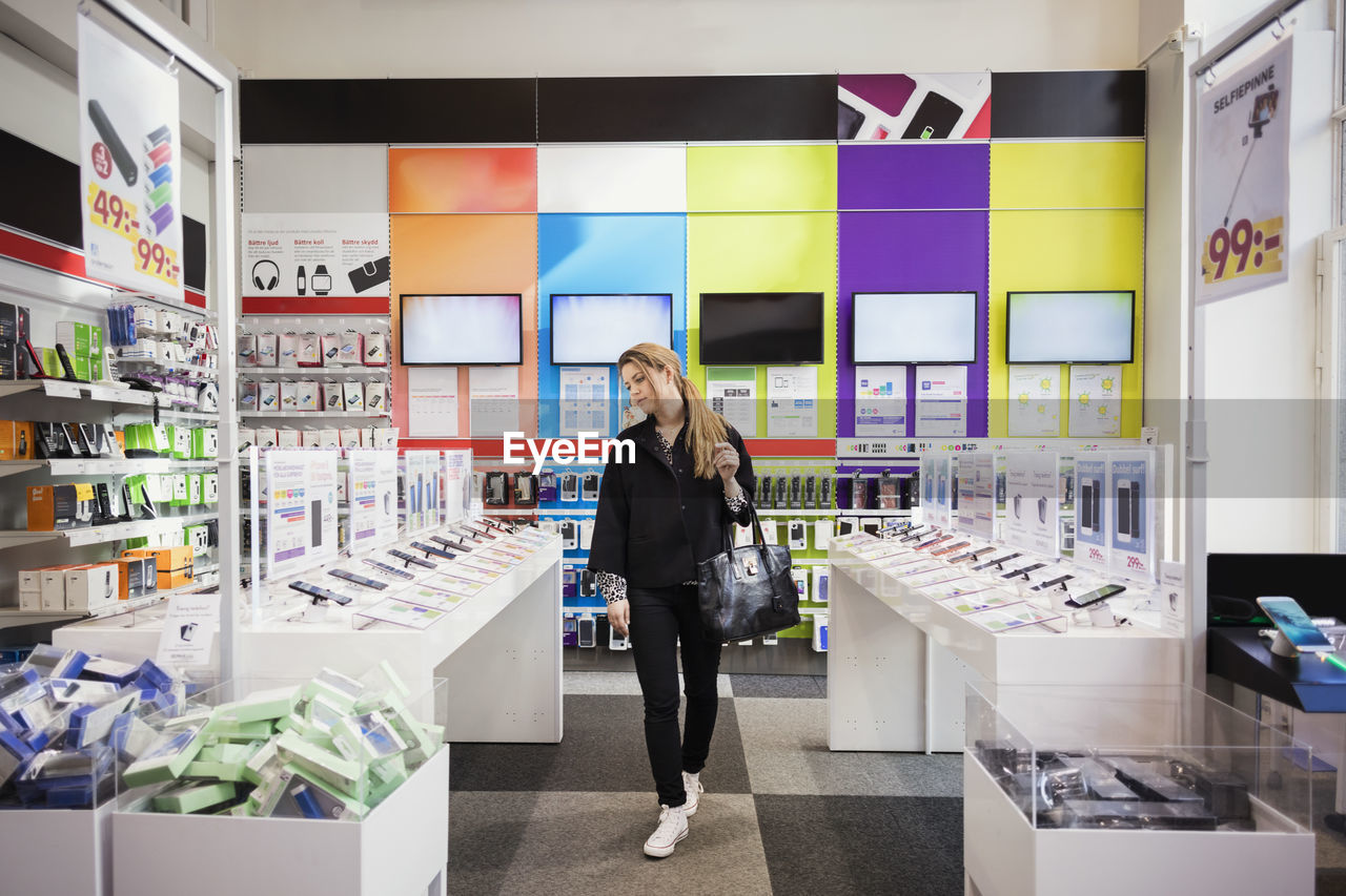 Female customer viewing smart phones in store