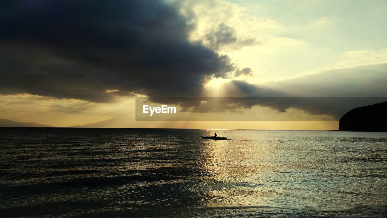 SILHOUETTE BOATS SAILING IN SEA AGAINST SKY DURING SUNSET