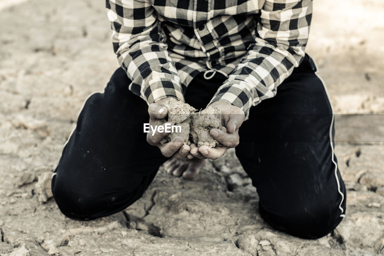 Woman kneeling on barren field