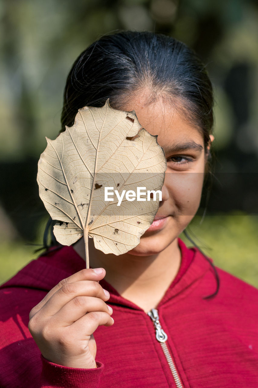 Close-up of young girl holding leaf