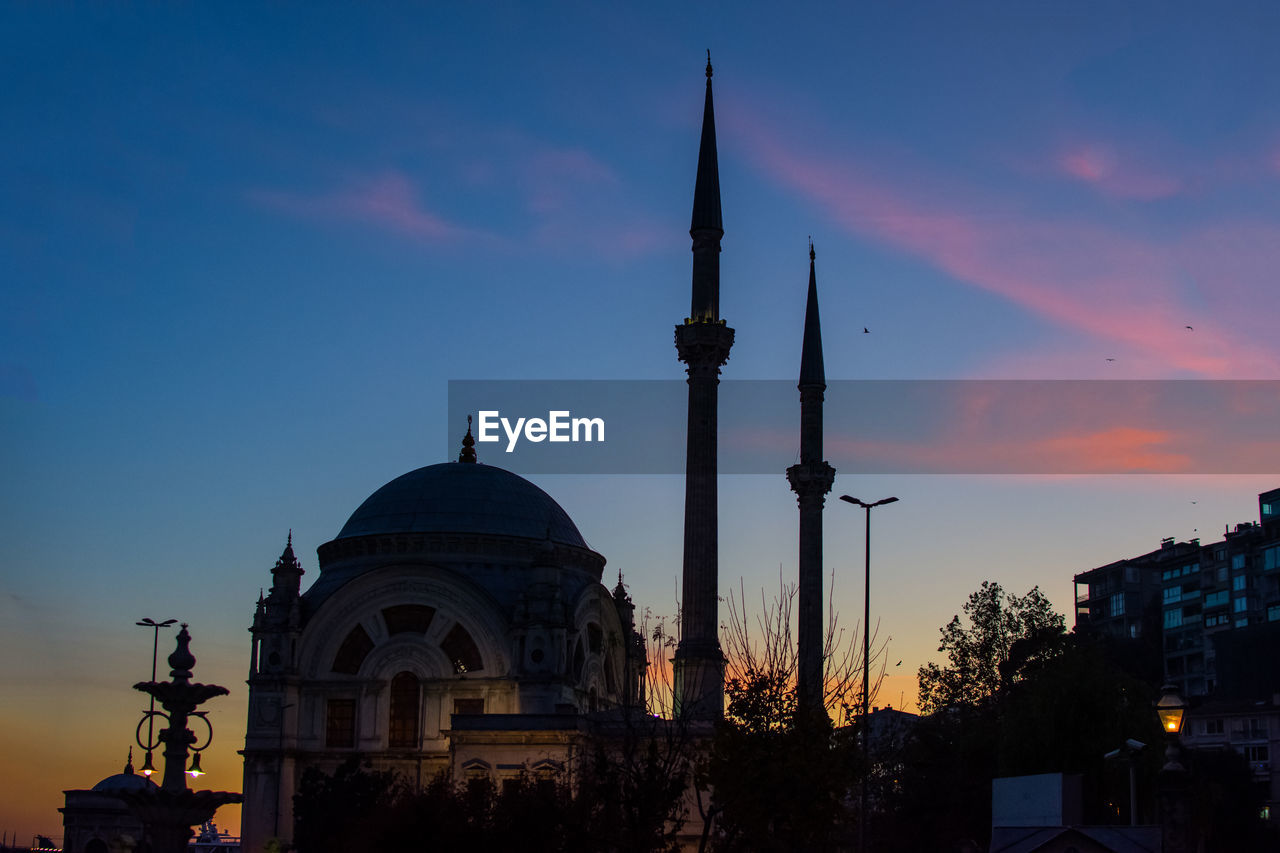 LOW ANGLE VIEW OF CHURCH AND BUILDINGS AGAINST SKY DURING SUNSET