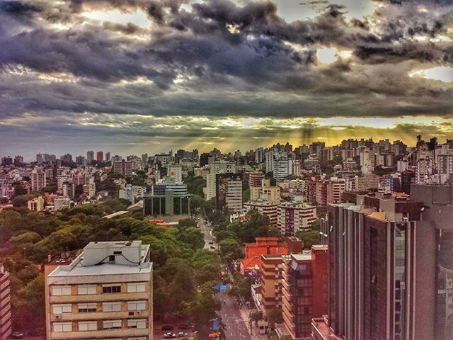 VIEW OF CITYSCAPE AGAINST CLOUDY SKY