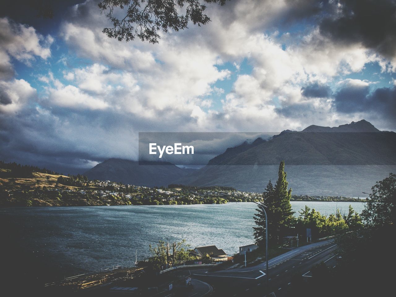 Scenic view of river and mountains against cloudy sky