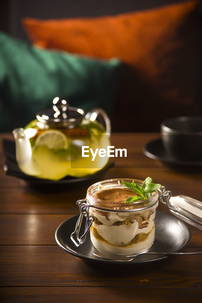 Close-up of tea served on table with tiramisu dessert