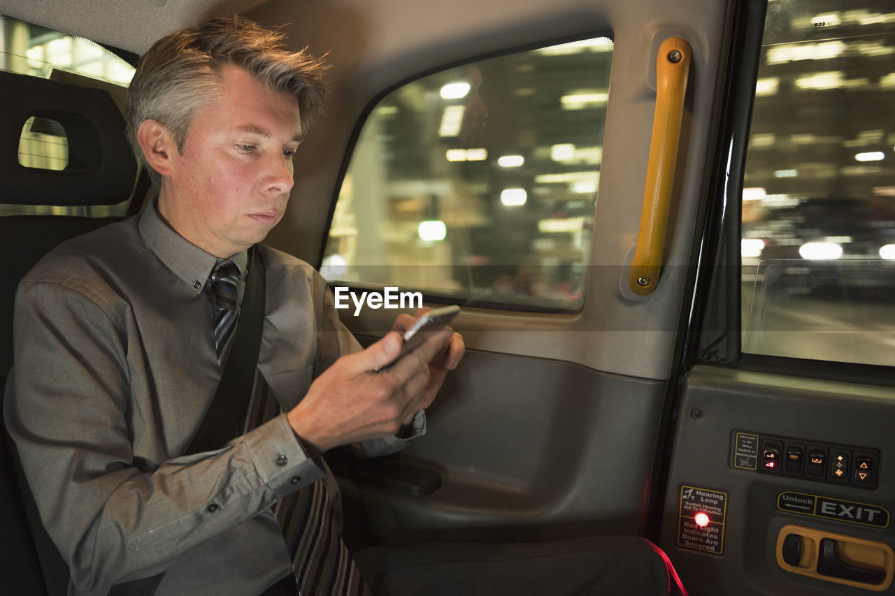 Man using phone while sitting in car